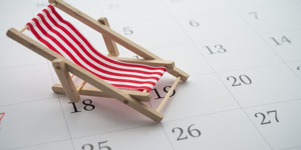 Red beach chair on white blank calendar background copy space. Annual leave travel period for relaxation concept. Period of paid time off (PTO) granted to employees by their employer.